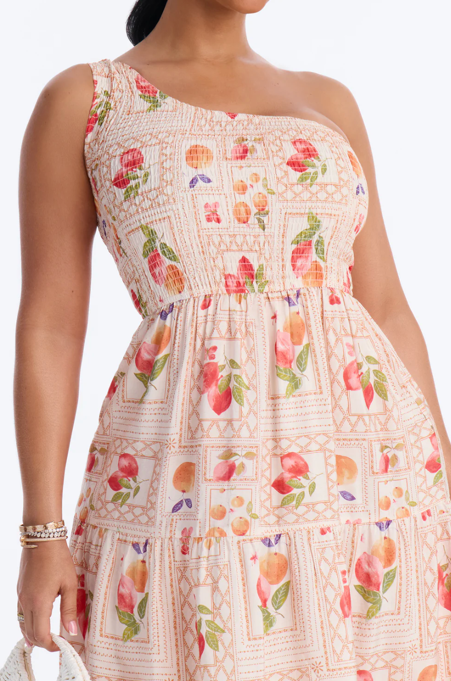 Woman wearing a floral one-shoulder dress with a blurred background